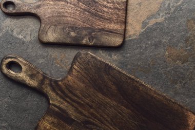 top view of brown wooden chopping boards on weathered grey background clipart