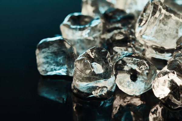 close up view of stack of transparent ice cubes on emerald background