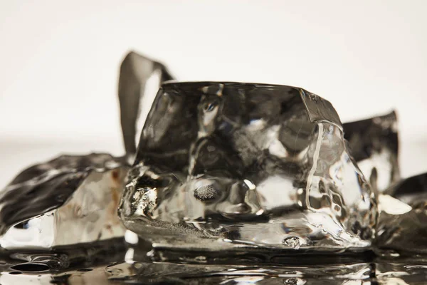 白い背景に透明な溶融氷の立方体のクローズアップビュー — ストック写真
