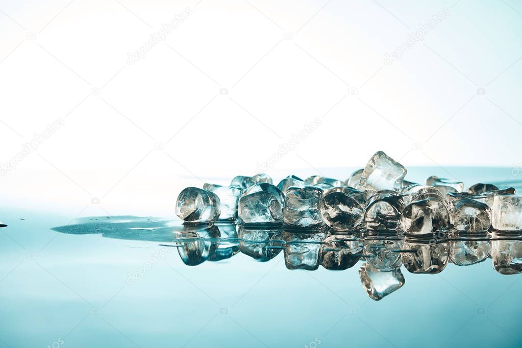 pure melting ice cubes on emerald and white background