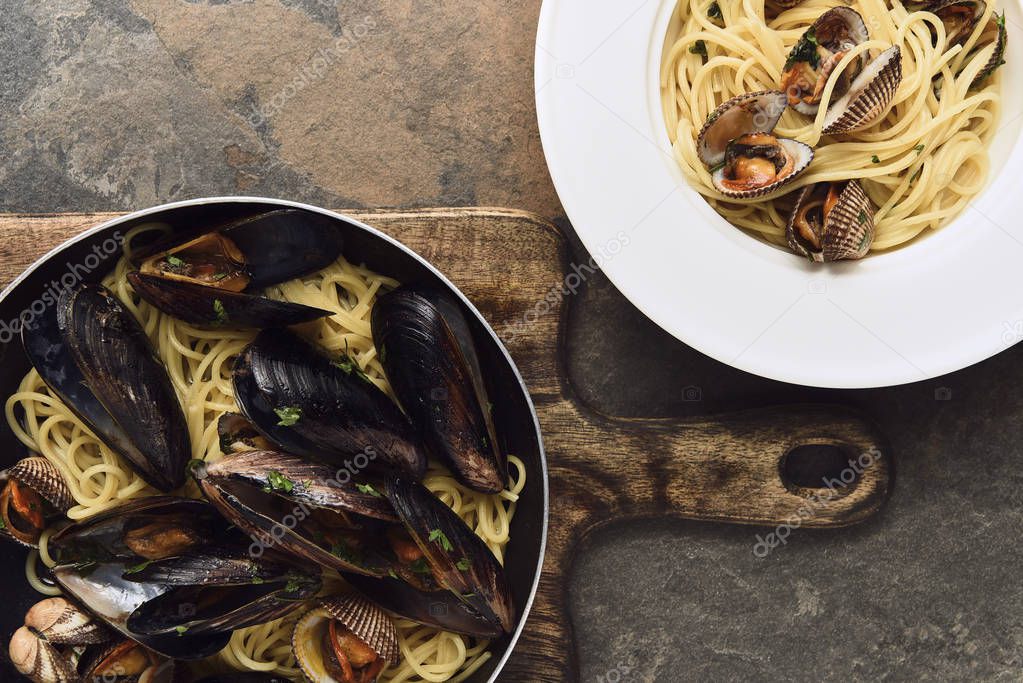 top view of delicious pasta with mollusks and mussels on weathered grey background