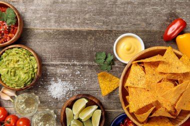 Meksika nachos üst görünümü peynir sosu, guacamole ve salsa yıpranmış ahşap masada servis