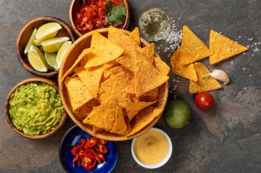 Meksika nachos üst görünümü tekila, ıhlamur, tuz, guacamole, peynir sosu ve salsa taş masada servis