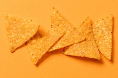 top view of delicious traditional crunchy Mexican nachos on orange background clipart