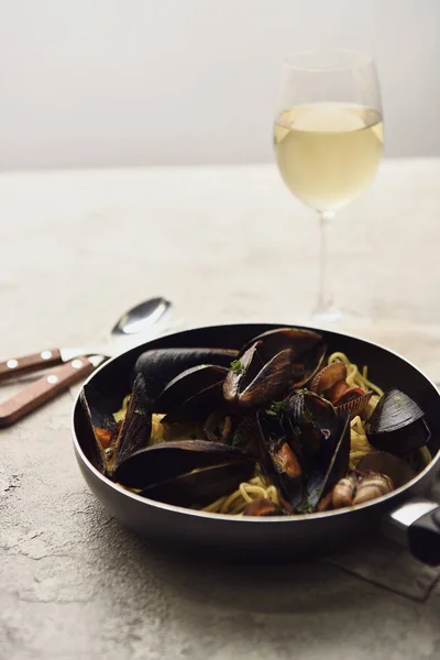选择性聚焦美味的意大利意大利面 海鲜在煎锅中供应 白葡萄酒在灰色上隔离 — 图库照片