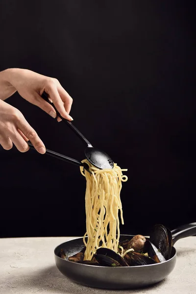 Siyah Izole Tavadan Deniz Ürünleri Ile Lezzetli Talyan Spagetti Alarak — Stok fotoğraf