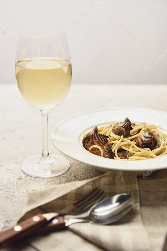 tasty Italian pasta with seafood served with white wine isolated on grey