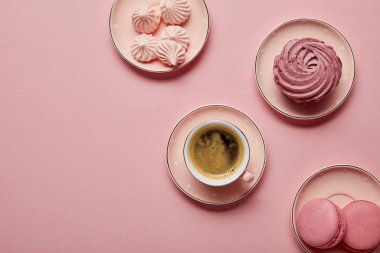 Bezeler, makaronlar ve pembe arka plan üzerinde kahve fincan ile pembe noktalı tabaküst görünümü