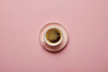 Pembe arka plan üzerinde beyaz nokta ile pembe tabakta aromatik kahve Fincan