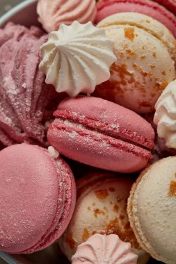 Delicious pink french macaroons with fluffy zephyr and small pink meringues with sugar pieces clipart