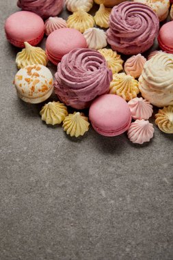 Lezzetli çeşitli küçük bezeler, gri arka plan üzerinde Fransız macaroons ile yumuşak zephyr