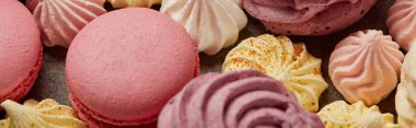Gurme tatlı pembe makaronlar, çeşitli küçük bezeler ve gri arka plan üzerinde zephyr