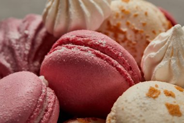 Delicious white macaroons sprinkled with chopped caramel with pink macaroons ans meringues clipart