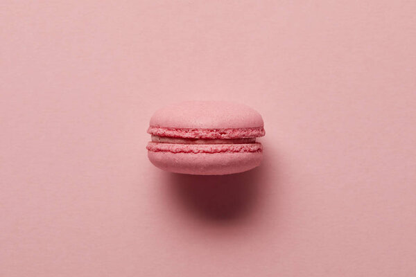 Pink french macaroon in center on pink background