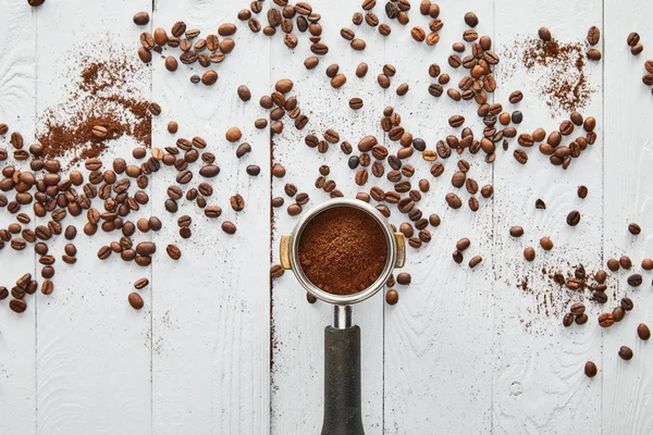 흩어져있는 콩이있는 표면에 커피가있는 포르타 필터의 — 스톡 사진