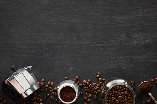 Top view of parts of geyser coffee maker near glass jar and spoon on dark wooden surface with coffee beans