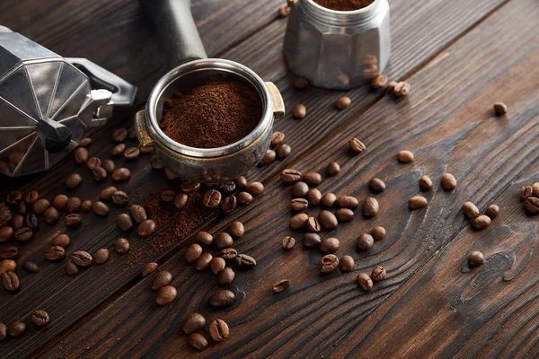 盖瑟咖啡壶靠近深棕色木质表面的Portafilter咖啡豆 — 图库照片