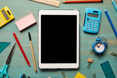 ahşap masada okul malzemeleri yakınında boş ekran ile dijital tablet üst görünümü