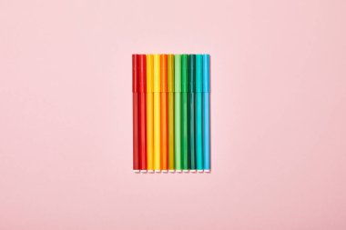 top view of multicolored felt pens isolated on pink clipart