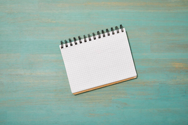 top view of empty blank notebook on wooden turquoise desk