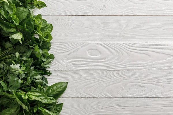 白い白い木製の表面にバジル シラントロ パセリ ペパーミントバンドルのトップビュー — ストック写真