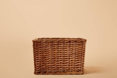 natural brown wicker basket on beige background clipart
