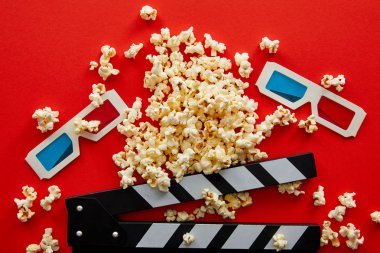 clapper kurulu ve kırmızı arka plan üzerinde 3d gözlük yakın lezzetli patlamış mısır üst görünümü