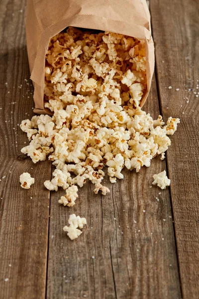 Deliciosas Palomitas Maíz Esparcidas Bolsa Papel Sobre Fondo Madera Con —  Fotos de Stock