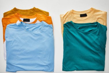 beyaz arka plan üzerinde bej, turuncu, mavi, turkuaz ve ochre t-shirt üst görünümü