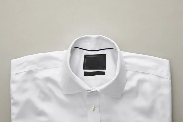 top view of white folded shirt on blue background