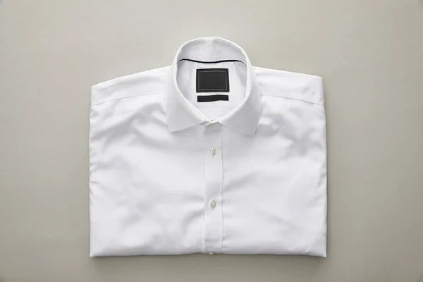 Vista Superior Camisa Plegada Blanca Sobre Fondo Gris Claro —  Fotos de Stock
