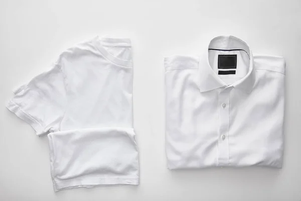 top view of blank t-shirt near plaid shirt on white background