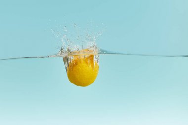 limon mavi arka plan üzerinde sıçrama ile su derin düşen