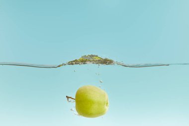 suda ıslatın ve kabarcıklar mavi zemin üzerine yeşil elma