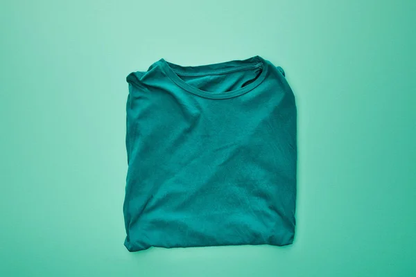 Επάνω Όψη Του Κενού Χρώματος Διπλωμένο Shirt Τυρκουάζ Φόντο — Φωτογραφία Αρχείου