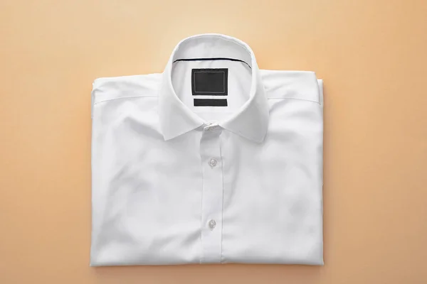 Vista Superior Camisa Dobrada Branca Lisa Fundo Bege — Fotografia de Stock