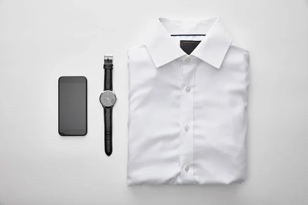 Plano Con Camisa Plegada Blanca Lisa Cerca Teléfono Inteligente Relojes — Foto de Stock