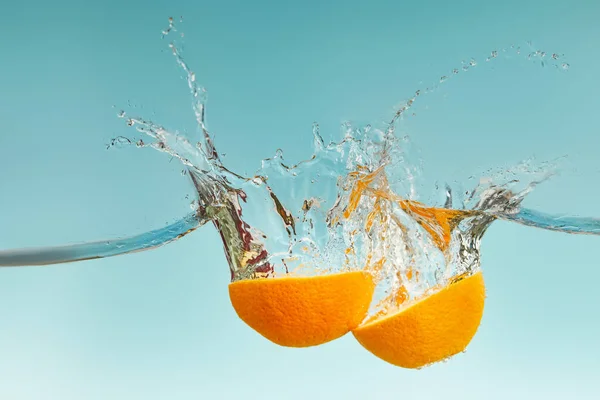 Metà Arancio Fresco Che Cade Acqua Con Spruzzi Sfondo Blu — Foto Stock