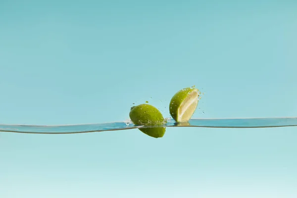 Mitades Cal Madura Cayendo Agua Sobre Fondo Azul — Foto de Stock