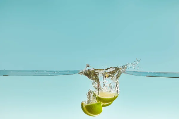 Metades Limão Caindo Profundamente Água Com Respingo Fundo Azul — Fotografia de Stock