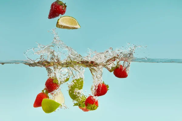 Lime Pieces Strawberries Falling Deep Water Splash Blue Background — Stock Photo, Image