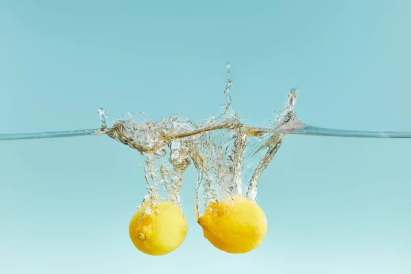 Limones Enteros Que Caen Profundamente Agua Con Salpicaduras Fondo Azul — Foto de Stock