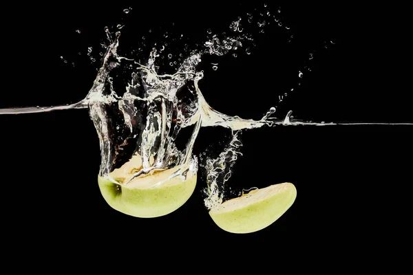 切成熟的苹果落入深水与飞溅孤立在黑色 — 图库照片