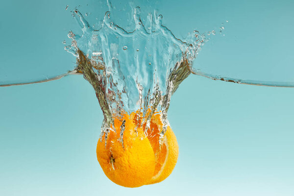 Ripe Orange Halves Falling Water Splashes Blue Background — Stock Photo, Image