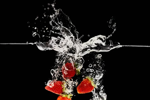 Красная Спелая Клубника Падающая Воду Брызгами Изолированными Черном — стоковое фото
