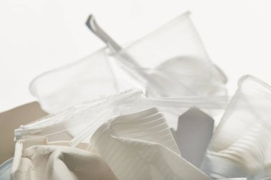 beyaz arka plan üzerinde buruşuk plastik ve karton çöp yakın görünümü
