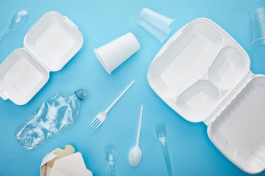 mavi arka plan üzerinde plastik ve karton çöp üst görünümü