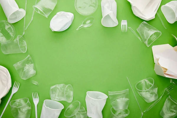 Bovenaanzicht Van Verfrommeld Plastic Bekers Vorken Kartonnen Container Groene Achtergrond — Stockfoto