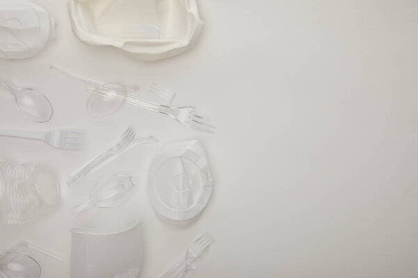 top view of crumpled disposable cups and plate on white background with copy space