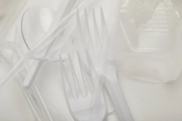 白色背景上皱褶的塑料杯 叉子和勺子的特写视图 — 图库照片